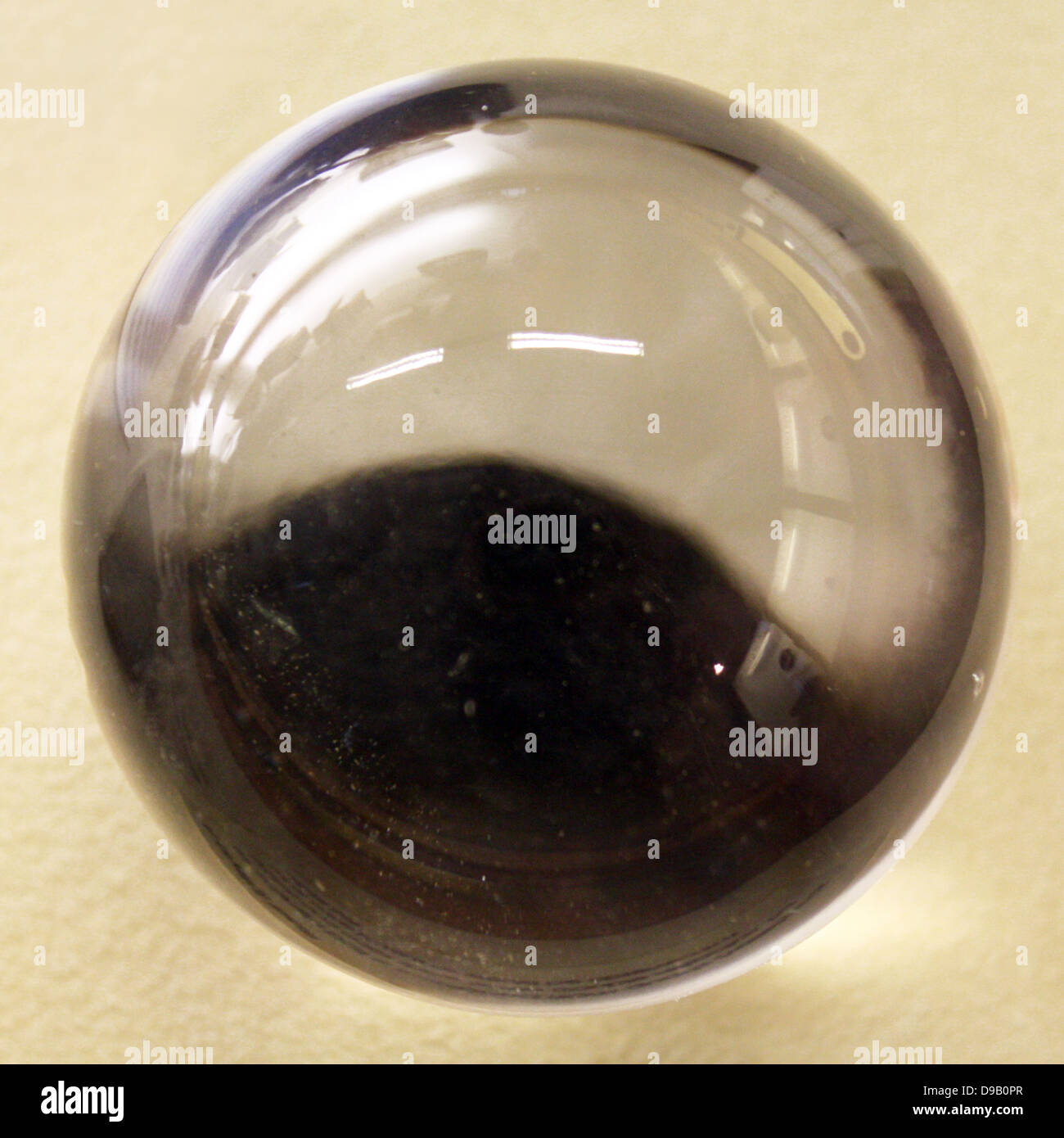 Una sfera di cristallo. Questa sfera lucidato è costituito di quarzo (varietà cristallo di rocca) e non mostrare alcuni doppia rifrazione, ma non come cospicua come potrebbe essere osservata in una sfera di calcite. Foto Stock