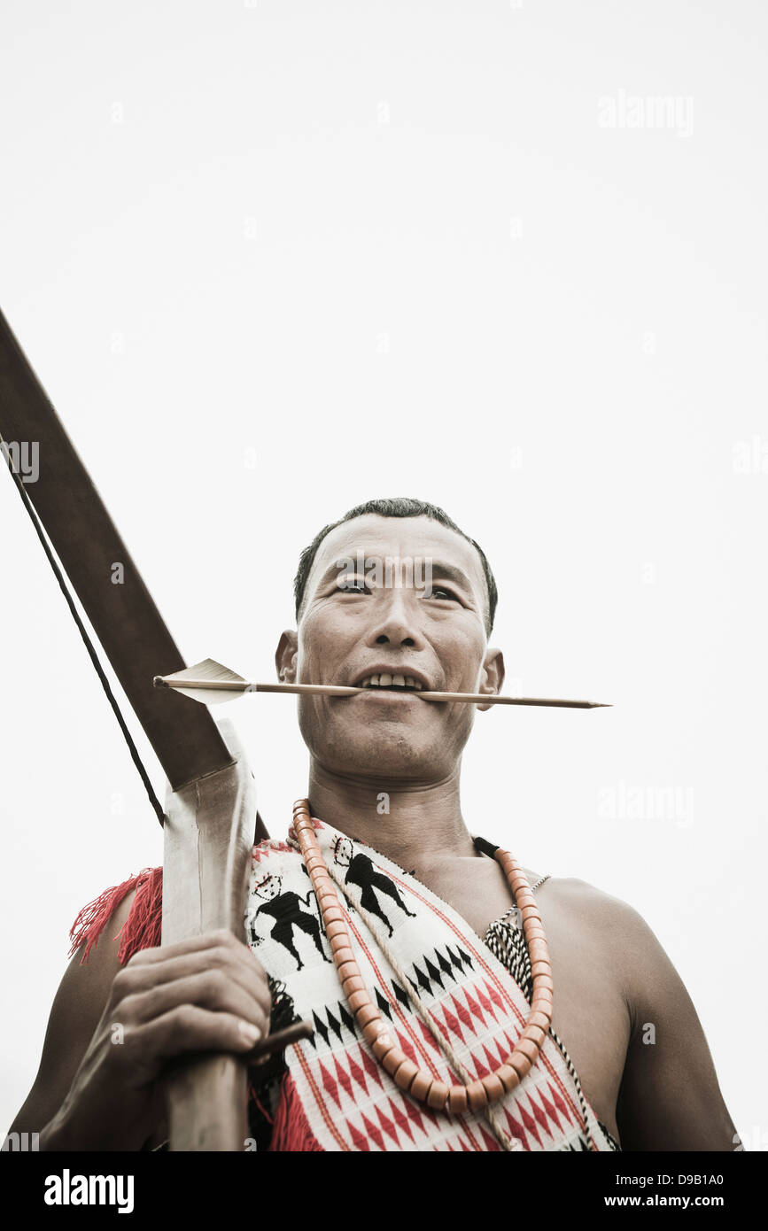 Naga guerriero tribale tenendo un arco trasversale, Hornbill Festival, Kohima, Nagaland, India Foto Stock