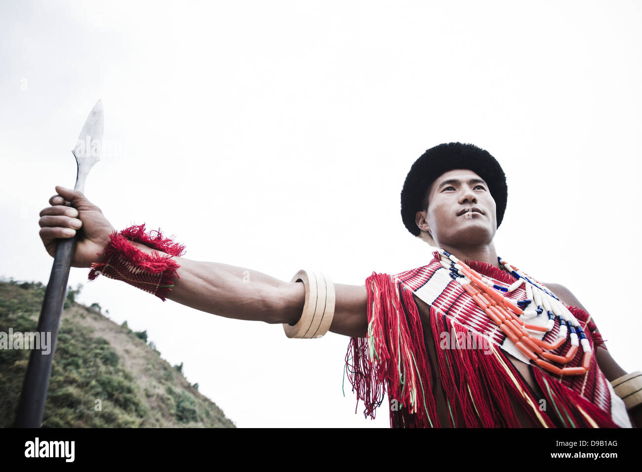 Naga guerriero tribale in piedi con la lancia, Hornbill Festival, Kohima, Nagaland, India Foto Stock