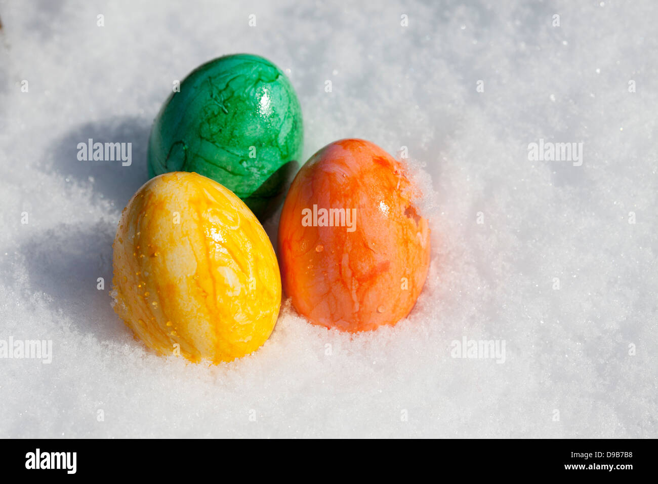 Tre colorate uova di Pasqua in neve, close up Foto Stock