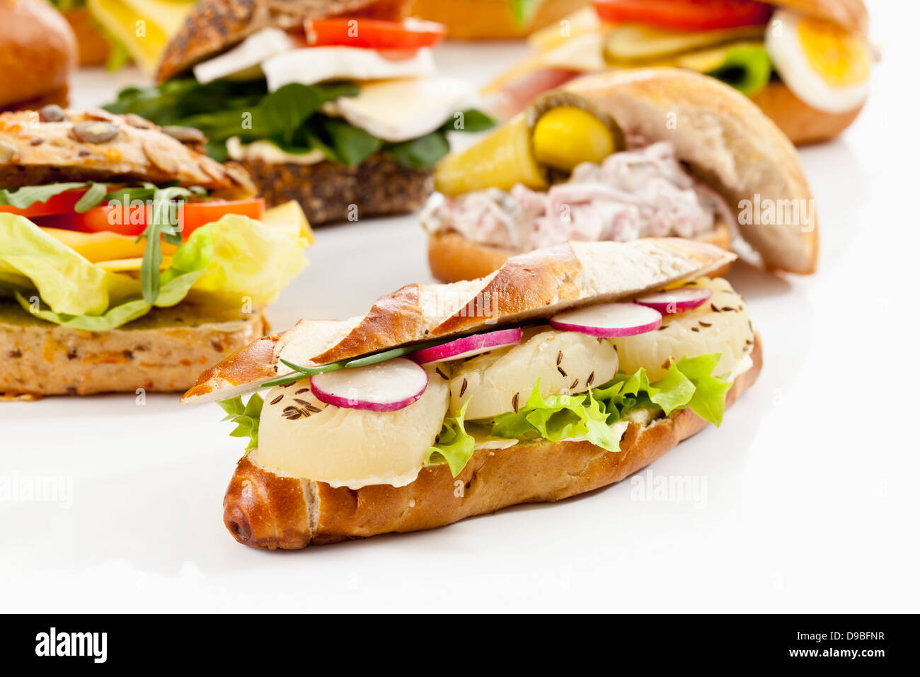 Varietà di pane con formaggio Harzer e ravanelli su sfondo bianco, close up Foto Stock