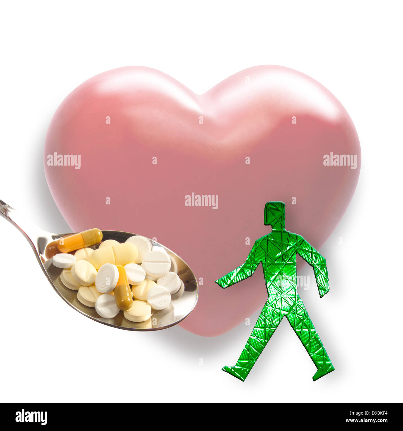Forma di cuore con figurine e cucchiaio di compresse in primo piano ravvicinato Foto Stock