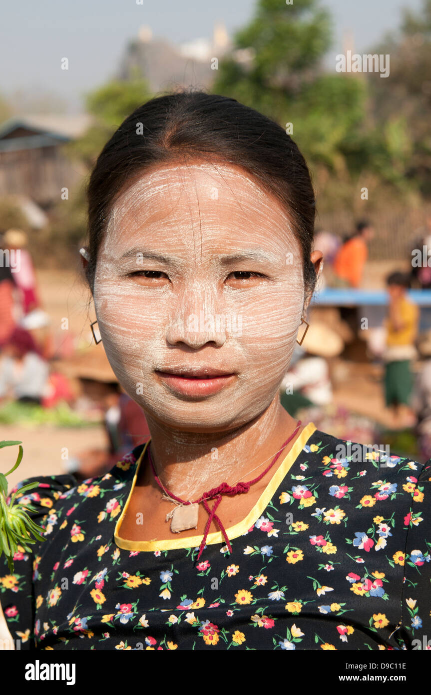 Testa e spalle il ritratto di una donna birmana con la faccia coperta in legno di sandalo thanakha incolla come specchio del Myanmar (Birmania) Foto Stock