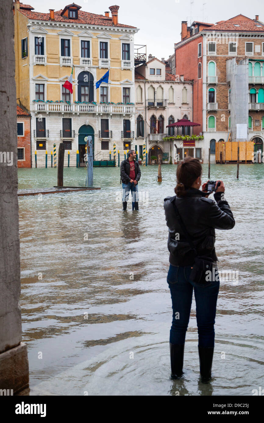 Acqua alta a Venezia, Italia. Acqua straripata terrazze. I turisti fotografare l'acqua. Foto Stock