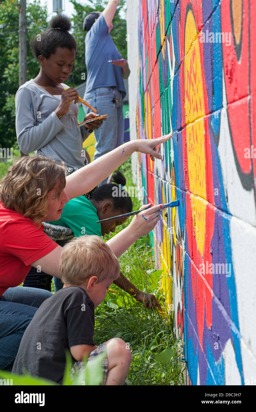 Detroit, Michigan - Volontari dipingere una parete di un negozio di alimentari. Foto Stock