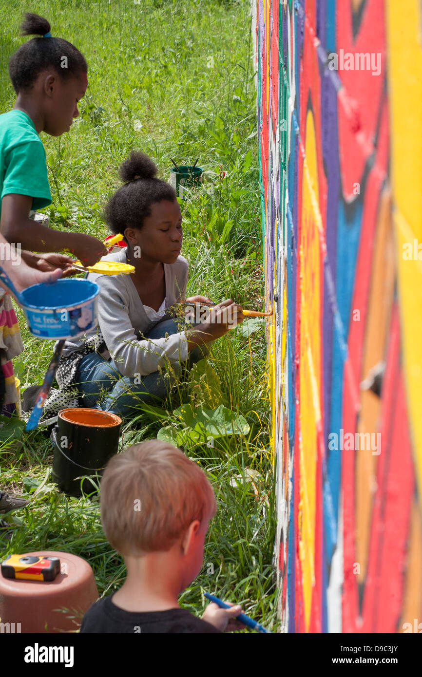 Detroit, Michigan - Volontari dipingere una parete di un negozio di alimentari. Foto Stock