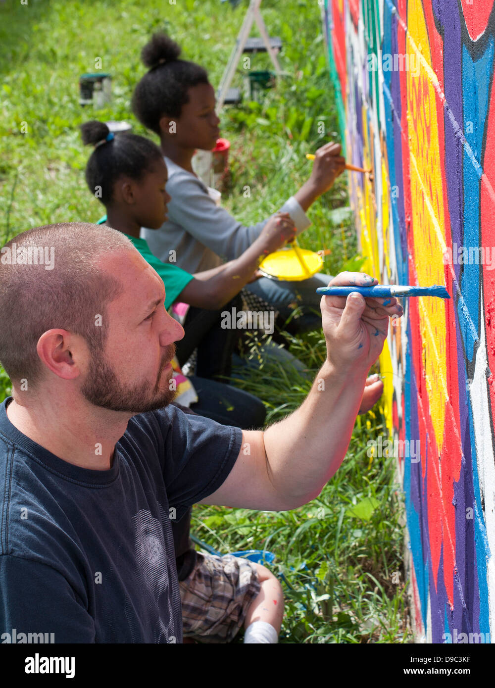 Detroit, Michigan - Volontari dipingere una parete di un negozio di alimentari. Foto Stock
