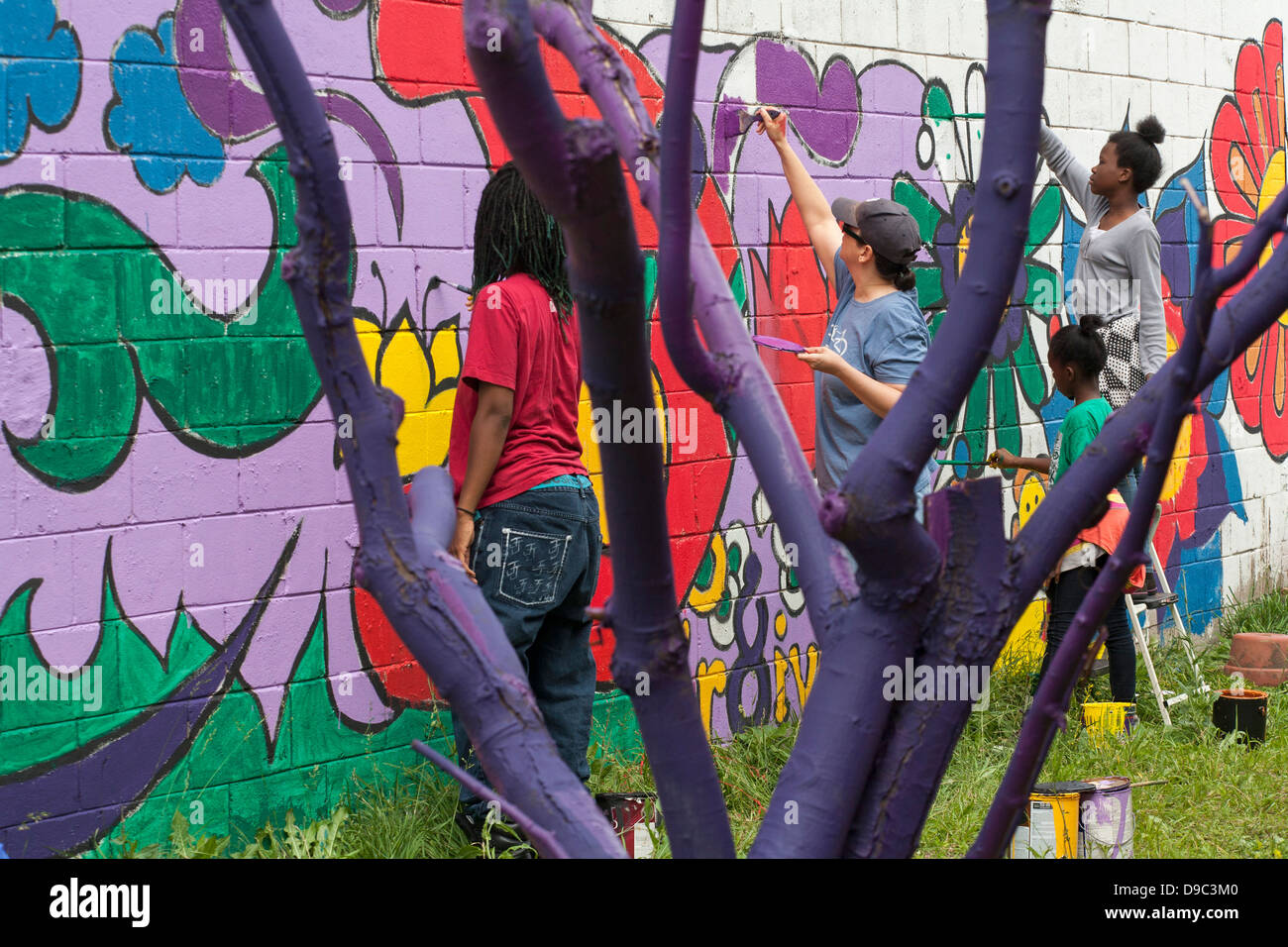 Detroit, Michigan - Volontari dipingere una parete di un negozio di alimentari. Foto Stock