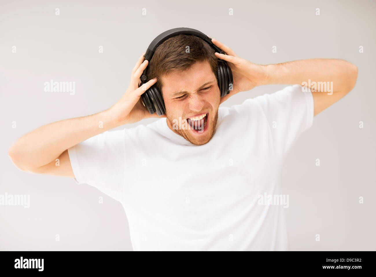 Uomo con le cuffie ascoltando la musica ad alto volume Foto stock - Alamy