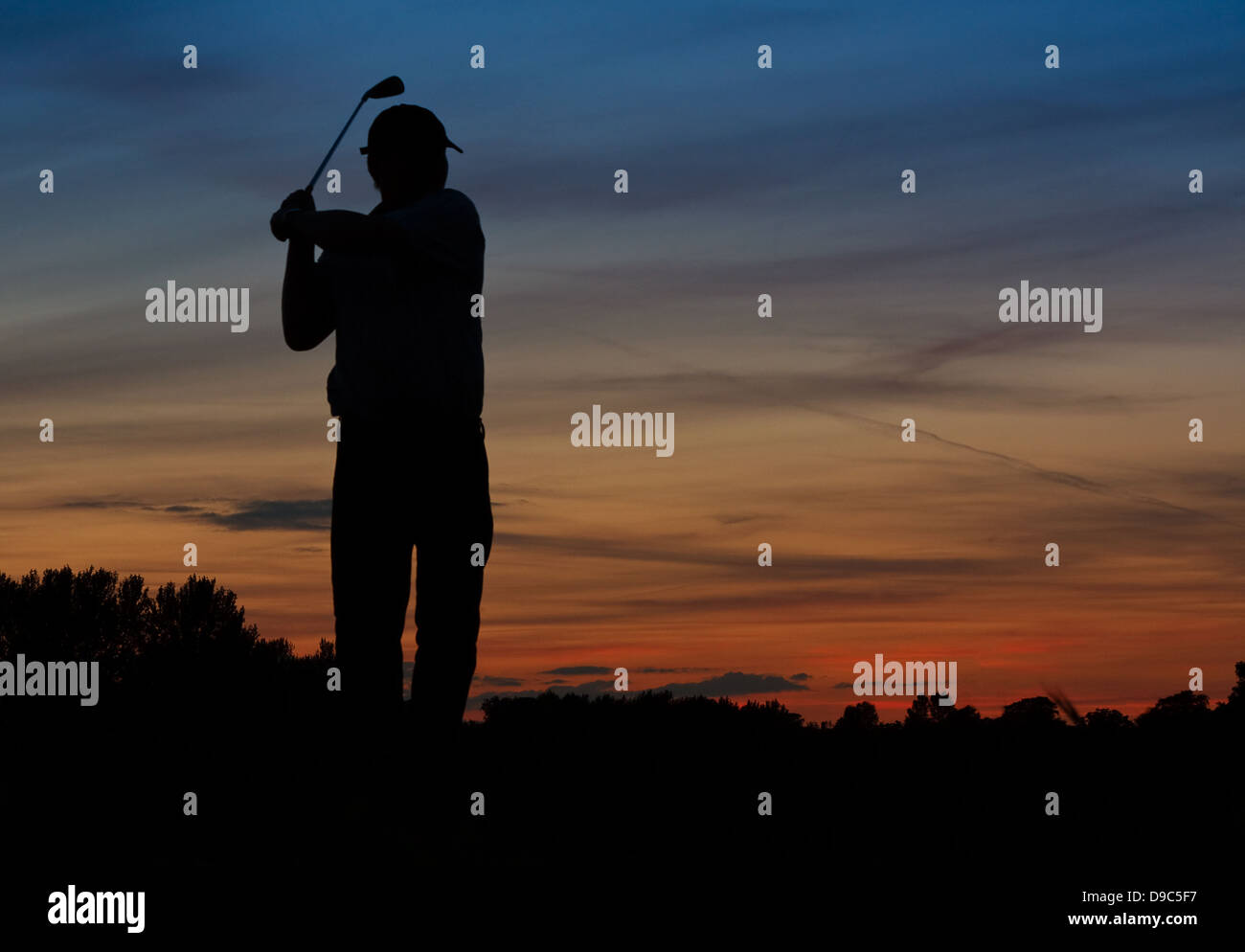 Silhouette di un giocatore di golf di rinvio presto fuori all'alba Foto Stock