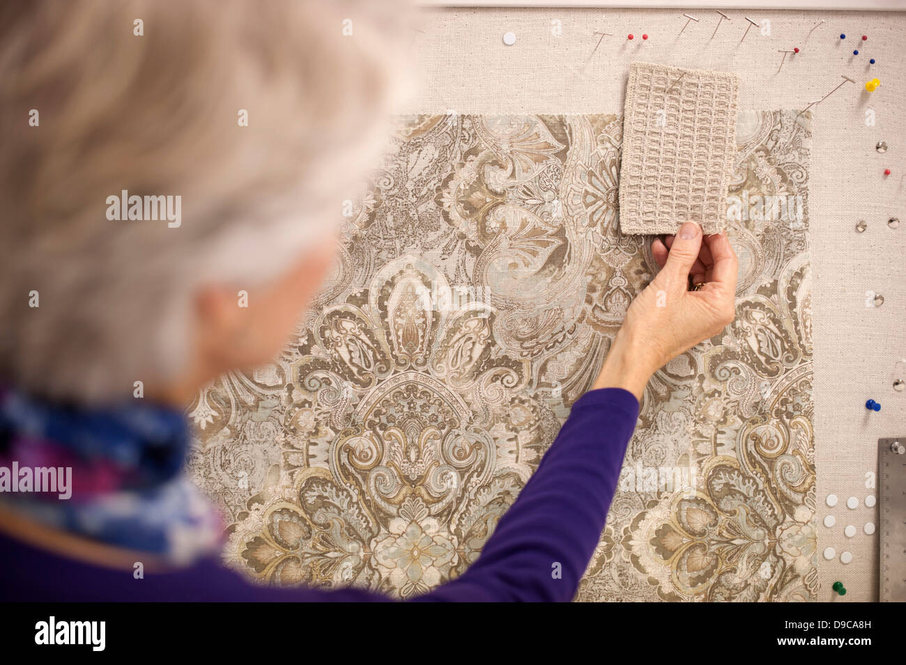 Senior donna scegliendo i campioni di materie tessili Foto Stock
