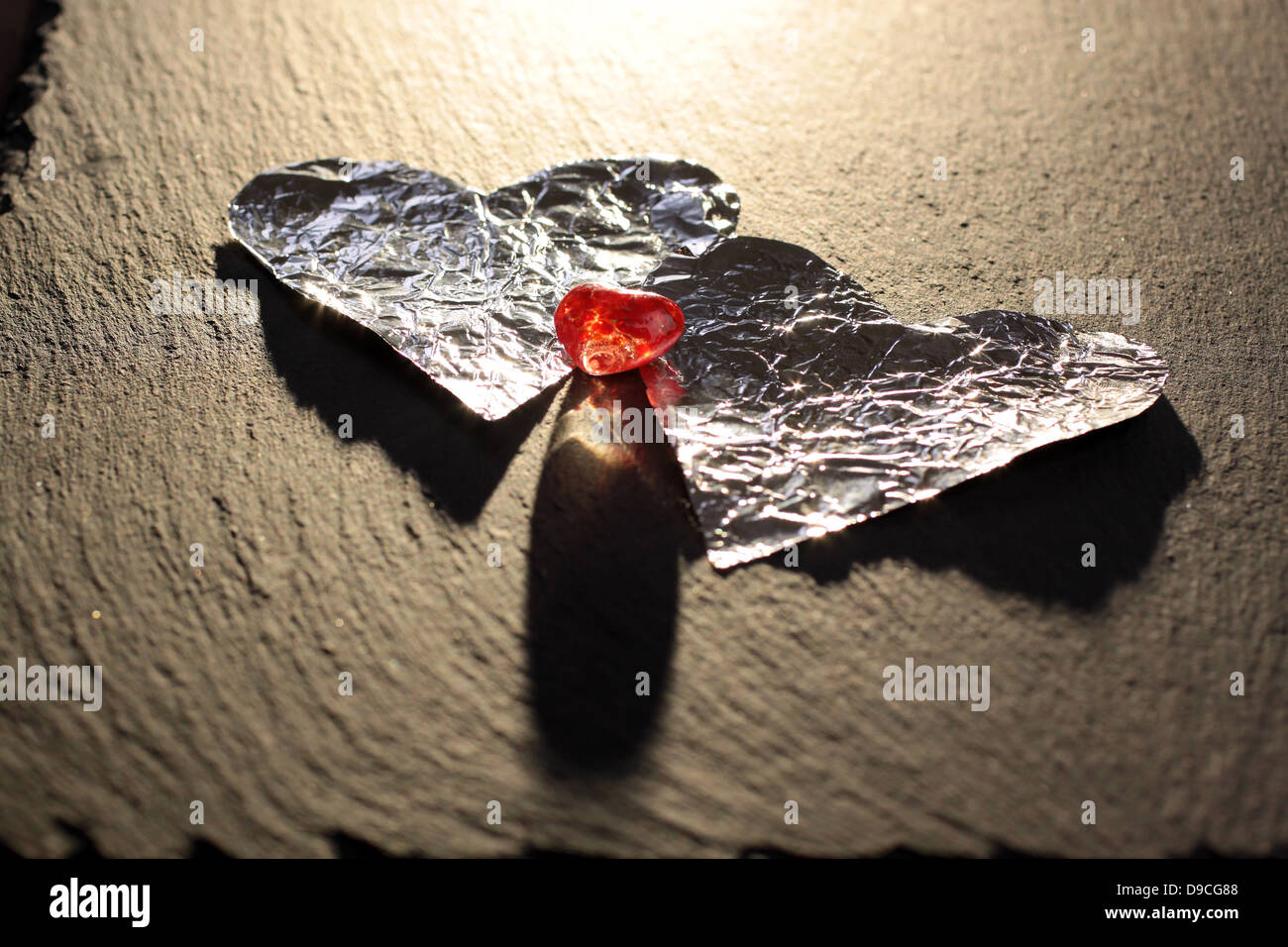 Due cuori in alluminio con uno rosso cuore di vetro Foto Stock