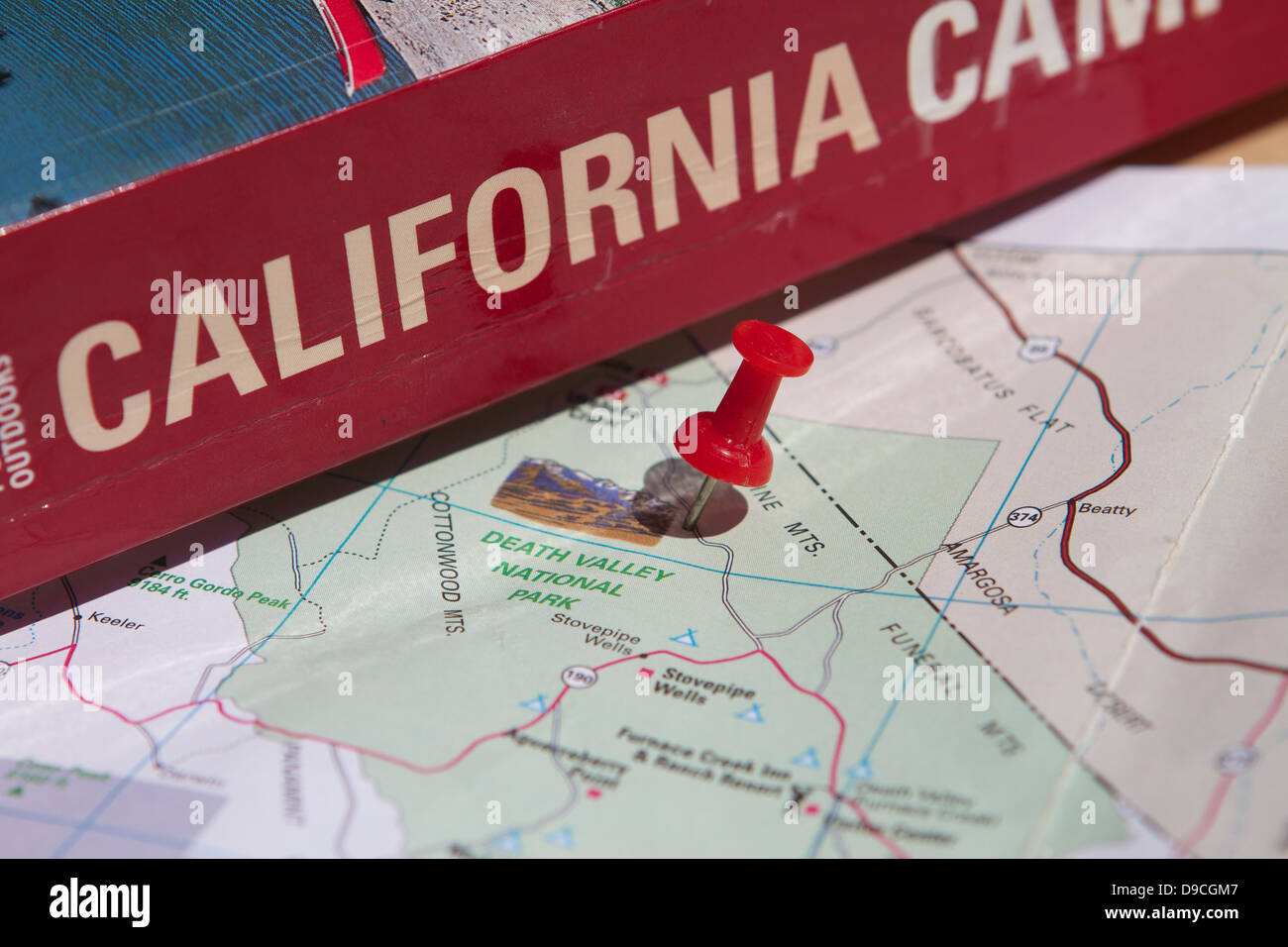 Una puntina da disegno marcatura parco nazionale della Valle della Morte su una mappa della California accanto a un California Camping prenota Foto Stock