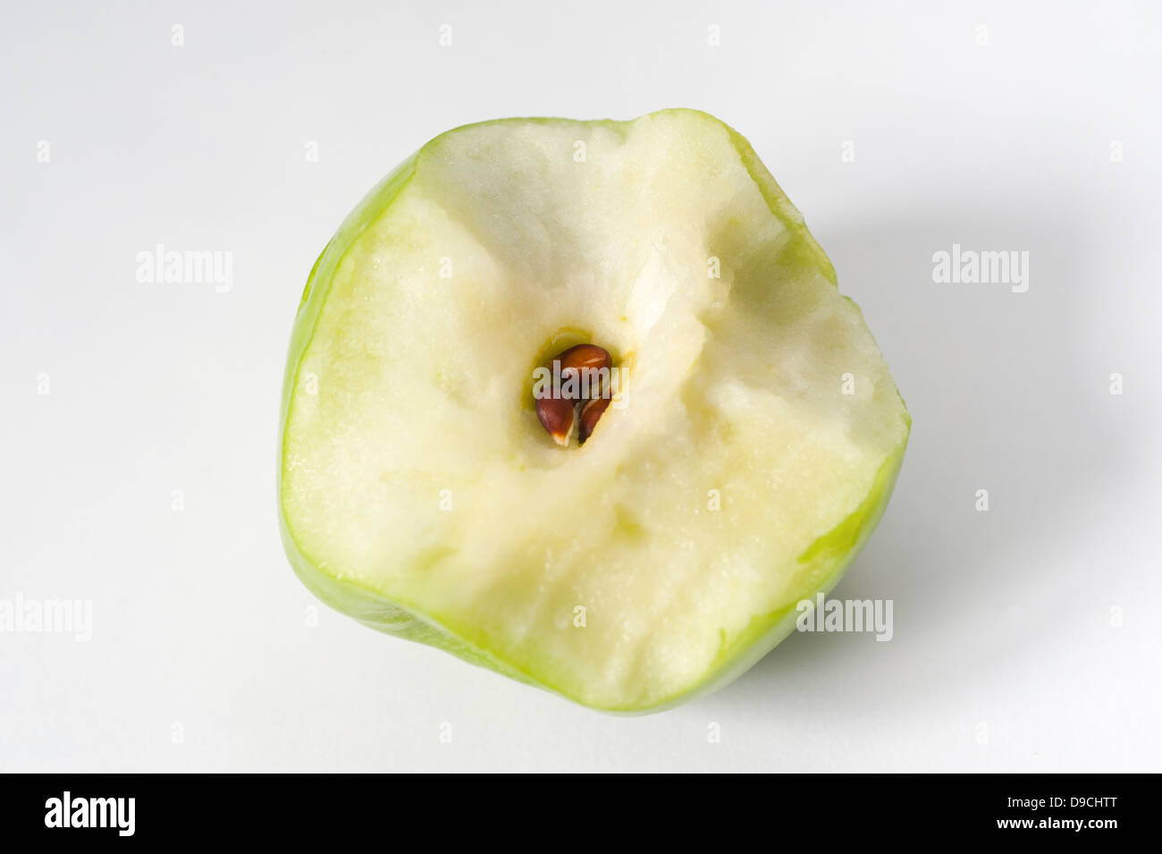 Una metà mangiato mela verde che mostra il nucleo e semi Foto Stock