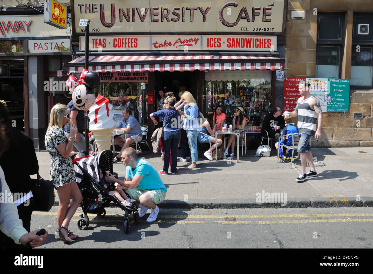 Una strada trafficata scena presso l'Università Café durante il west end festival su Byres Road, Glasgow, Scotland, Regno Unito Foto Stock