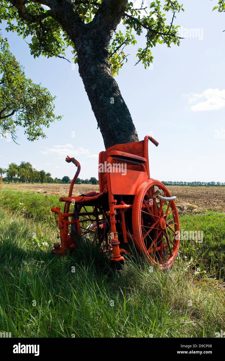 Sedia a rotelle in un albero come un avvertimento per troppo rapidamente spostando i motociclisti, sedia a rotelle per un albero ace un avvertimento per il viaggio troppo un Foto Stock