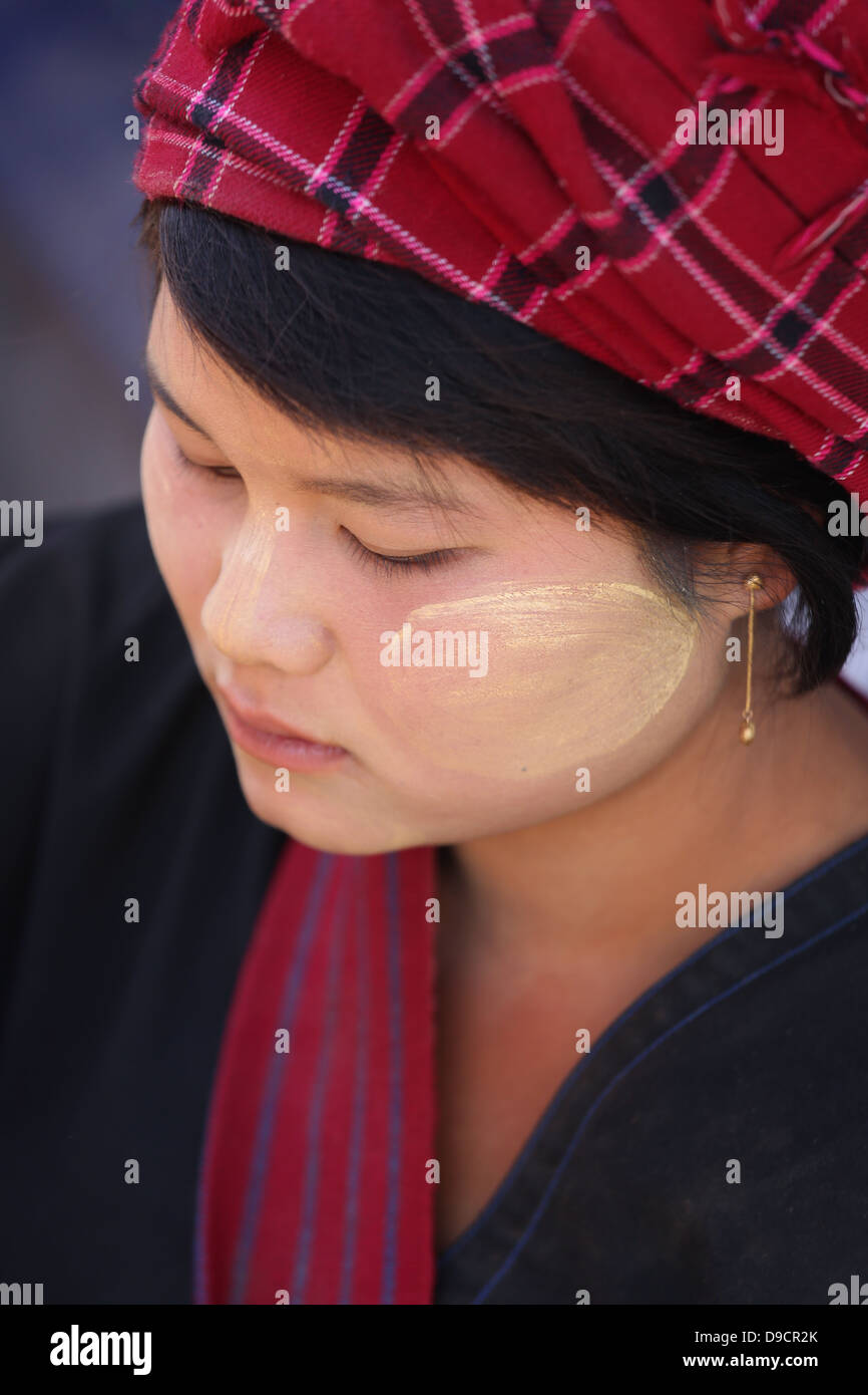 Giovane donna indossa Thanaka viso Crema e panno rosso turbante dalla tribù Shan a Thaung Tho mercato in Myanmar Asia SE Foto Stock