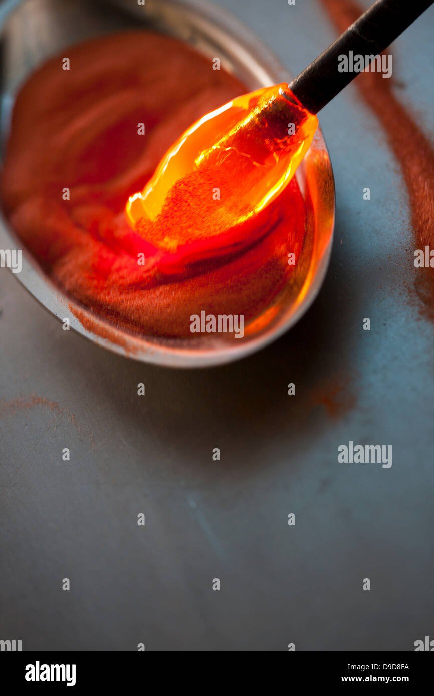 Red Hot essendo di vetro immerso nella sabbia in fabbrica del vetro Foto Stock