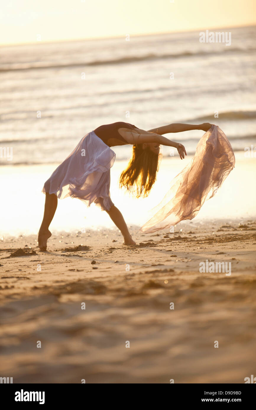 Giovane donna balli sulla spiaggia soleggiata Foto Stock