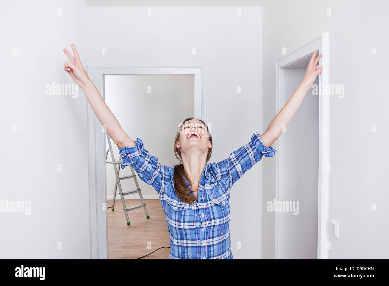 La donna che mostra V segno, sorridente Foto Stock