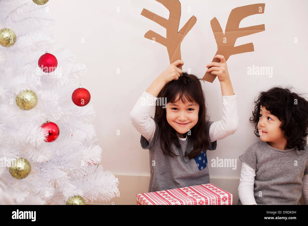 Due ragazze la preparazione per il Natale, e giocando con le renne di cartone palchi Foto Stock