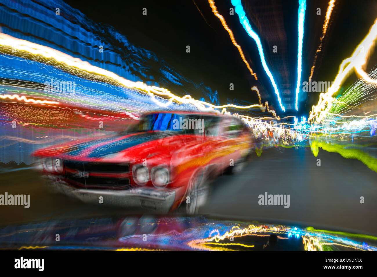 Auto rossa muovendosi attraverso la città di notte Foto Stock