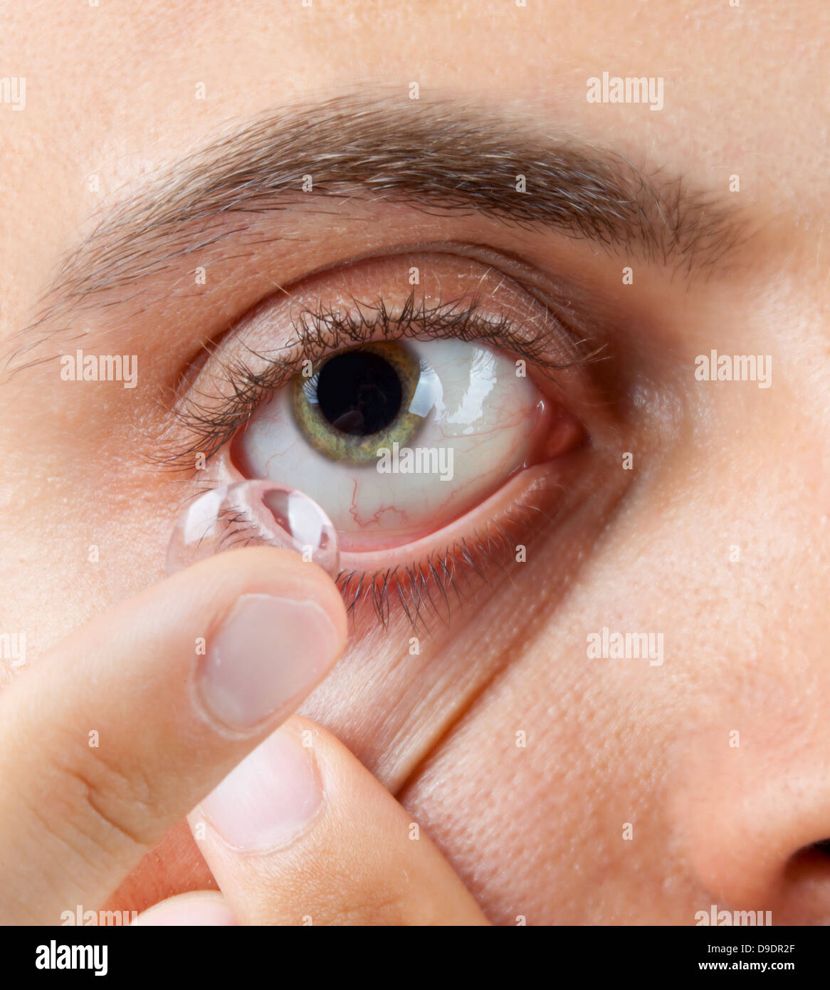 Primo piano di un uomo verde dell'occhio durante l'inserimento di un correttivo Foto Stock