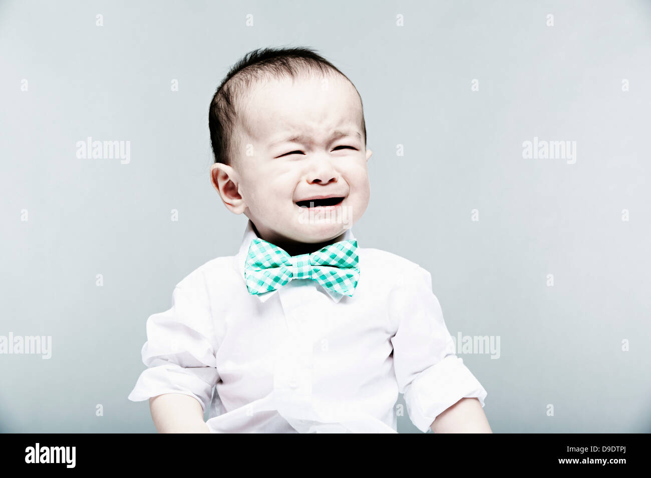 Ritratto di baby boy indossando camicia e il filtro bow tie, pianto Foto Stock