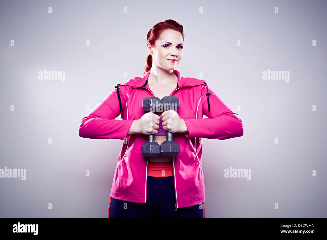 Giovane donna utilizzando i pesi a mano Foto Stock