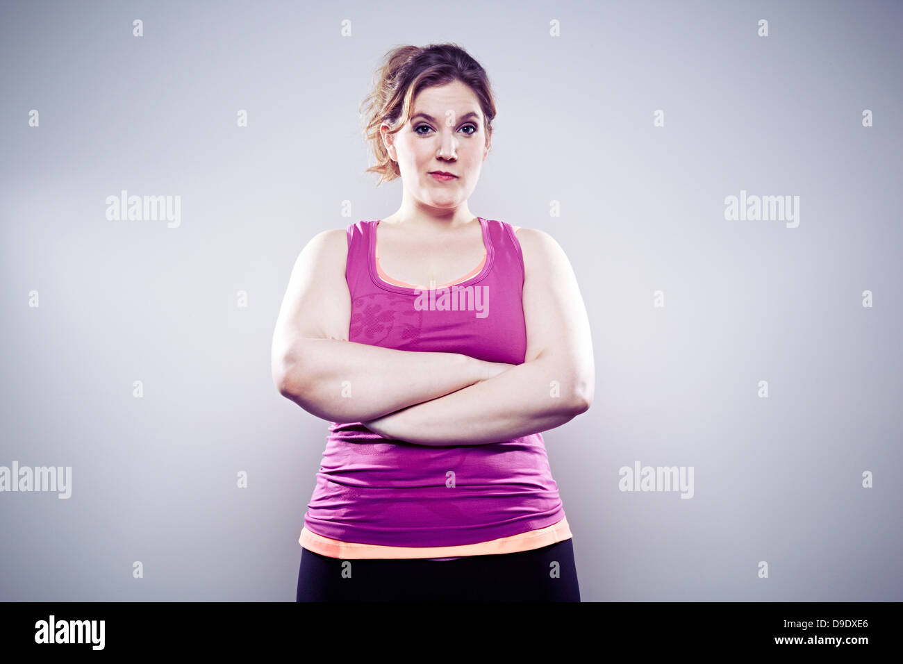 Giovane donna indossa giubbotto viola, con le braccia incrociate Foto Stock