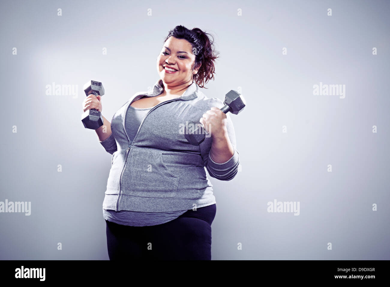 Metà donna adulta utilizzando i pesi a mano Foto Stock