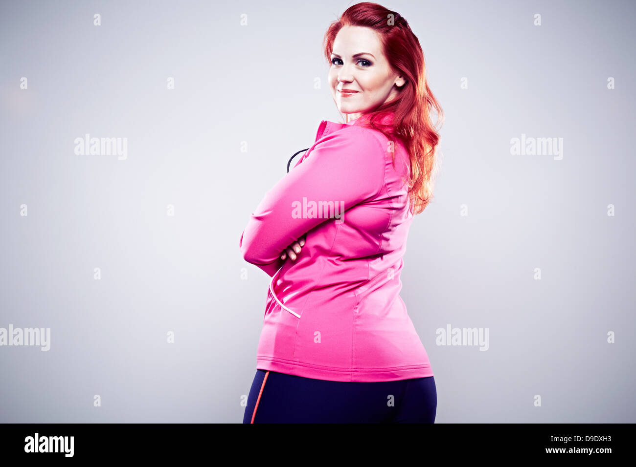 Giovane donna indossa top rosa, bracci ripiegati Foto Stock