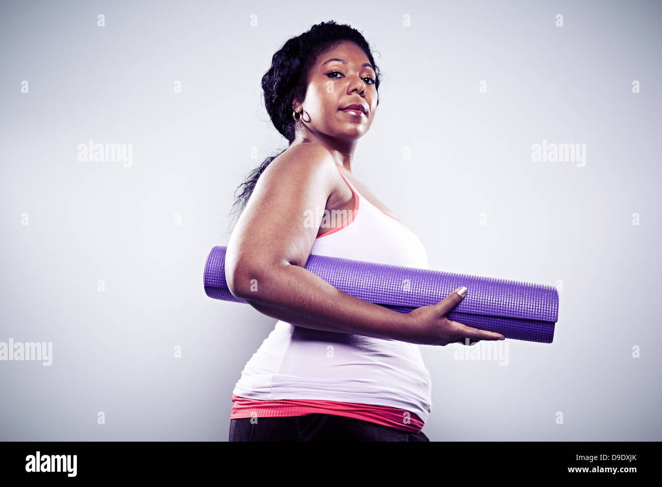 Metà donna adulta azienda materassino yoga Foto Stock