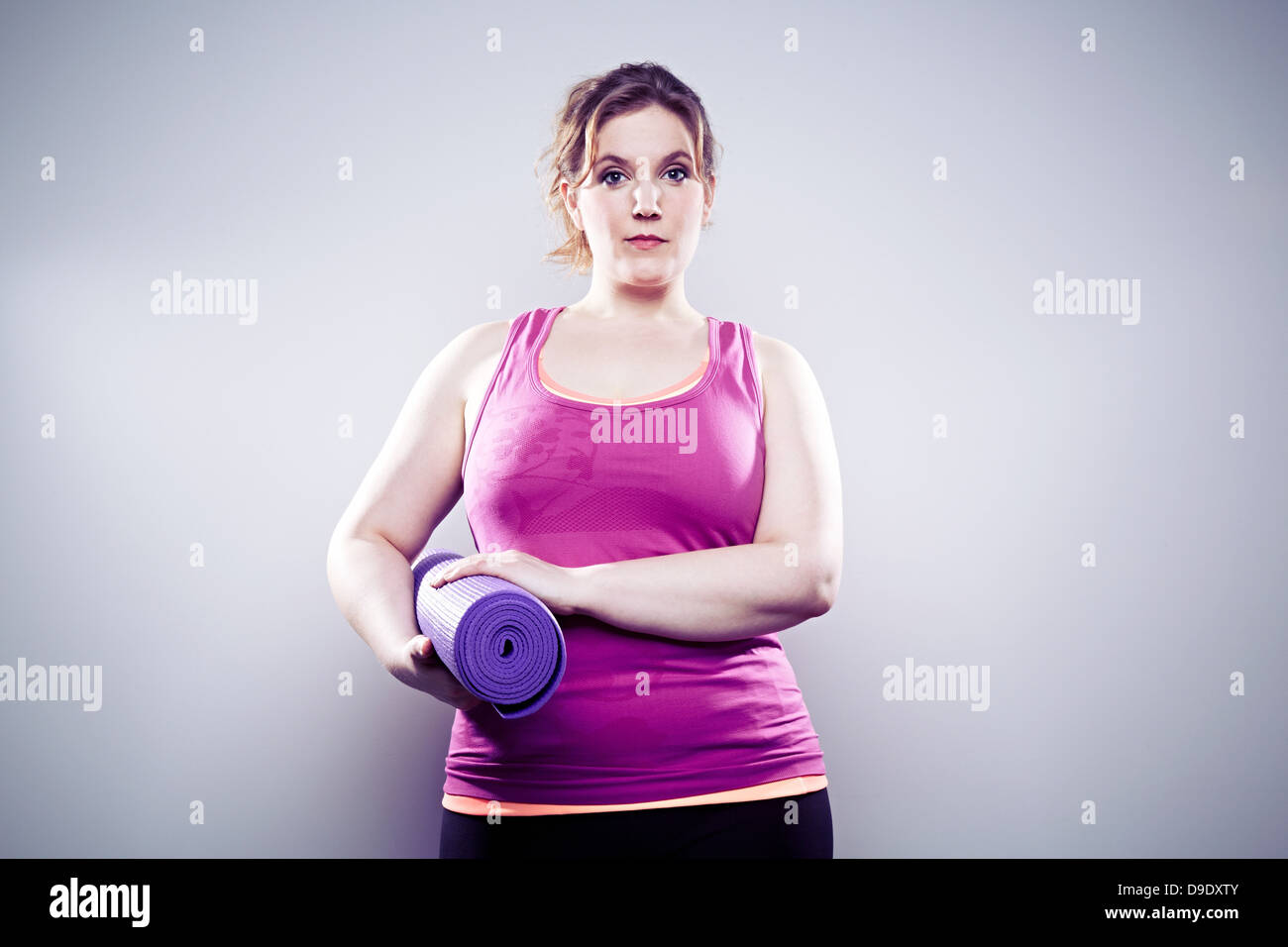 Giovane donna azienda materassino yoga Foto Stock
