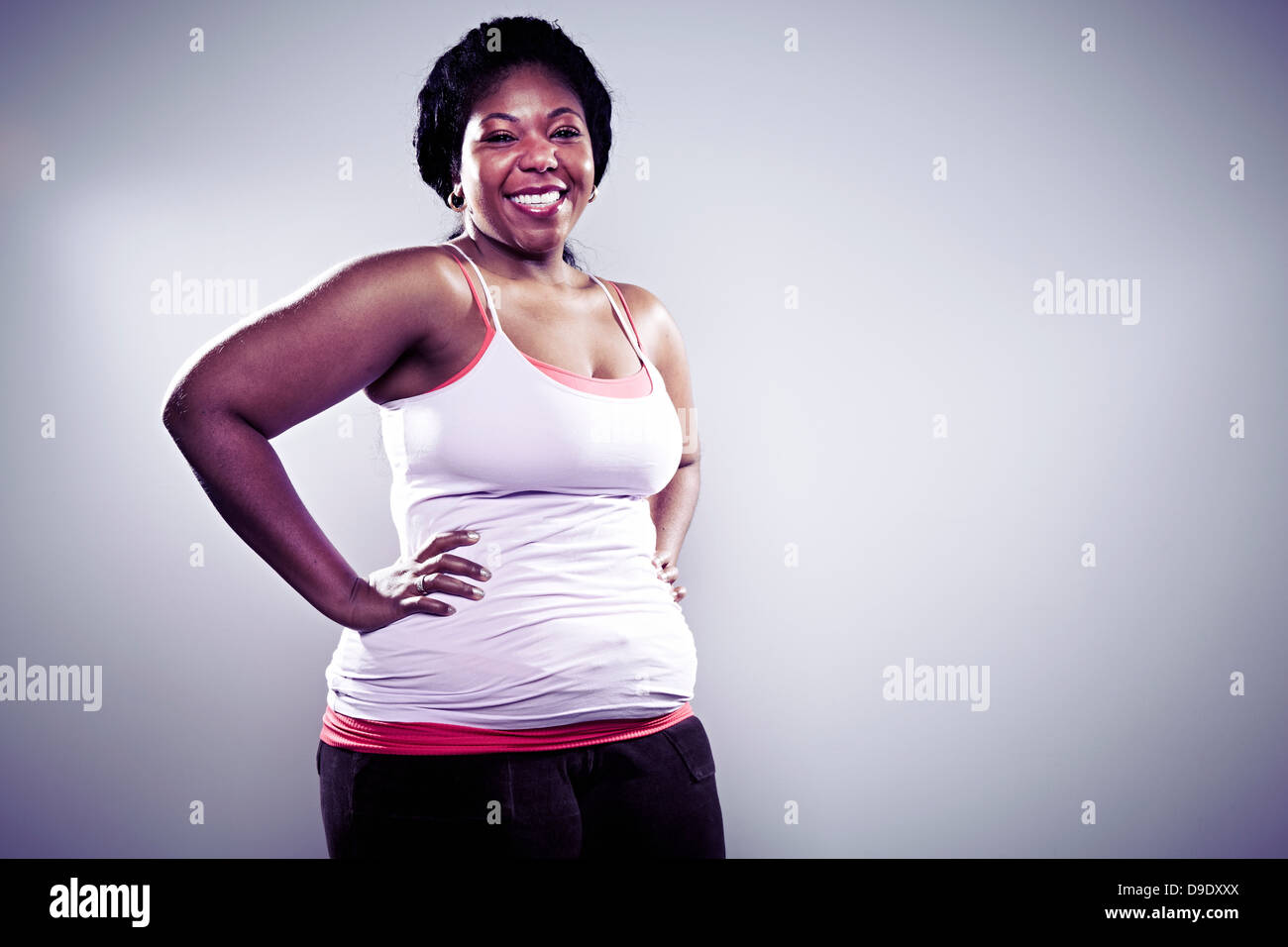 Metà donna adulta indossando bianco Gilet, mani sui fianchi Foto Stock