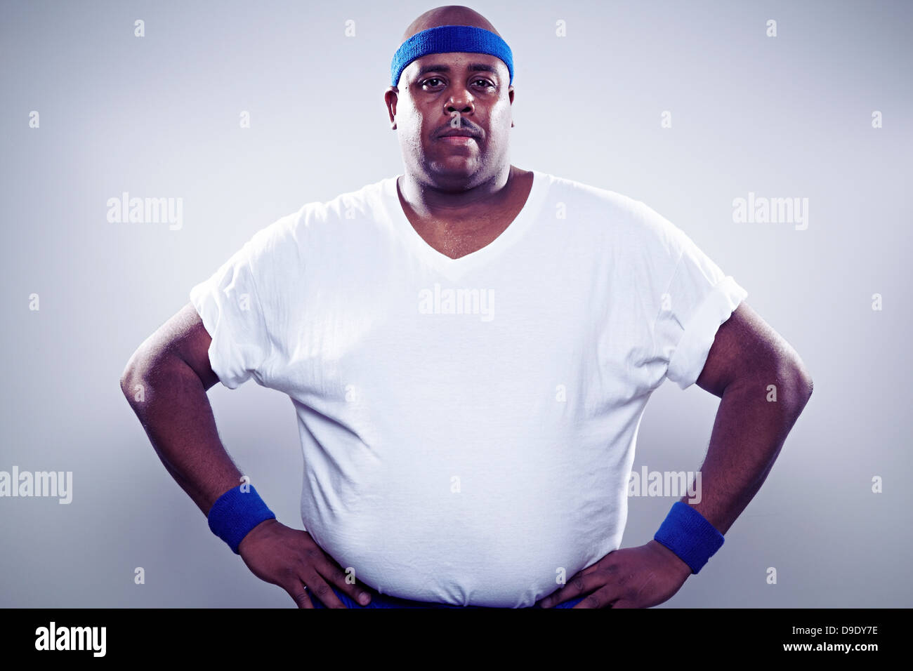 Uomo maturo indossando white t shirt, mani sui fianchi Foto Stock