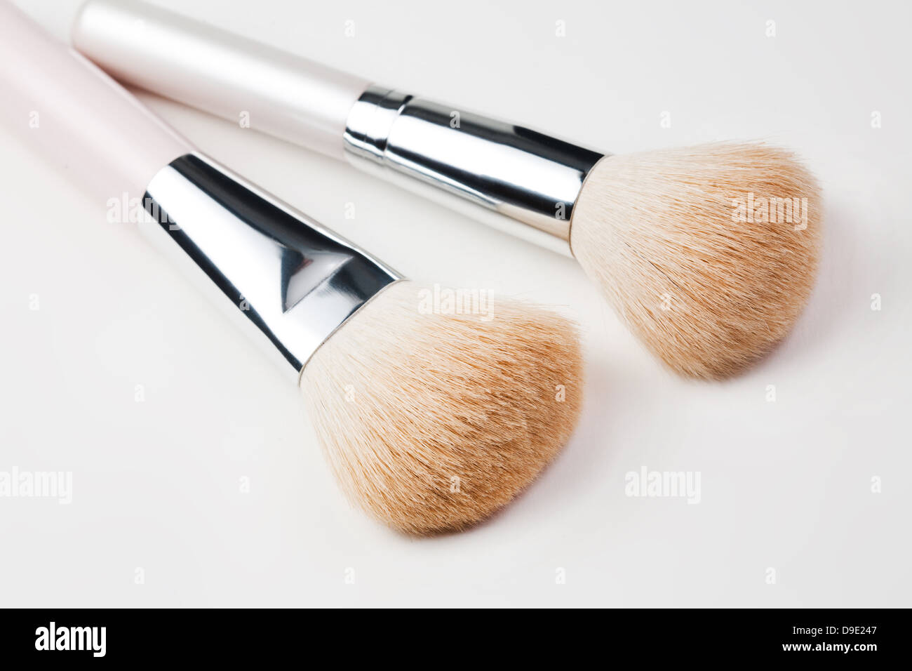 Spazzole cosmetiche su bianco Foto Stock