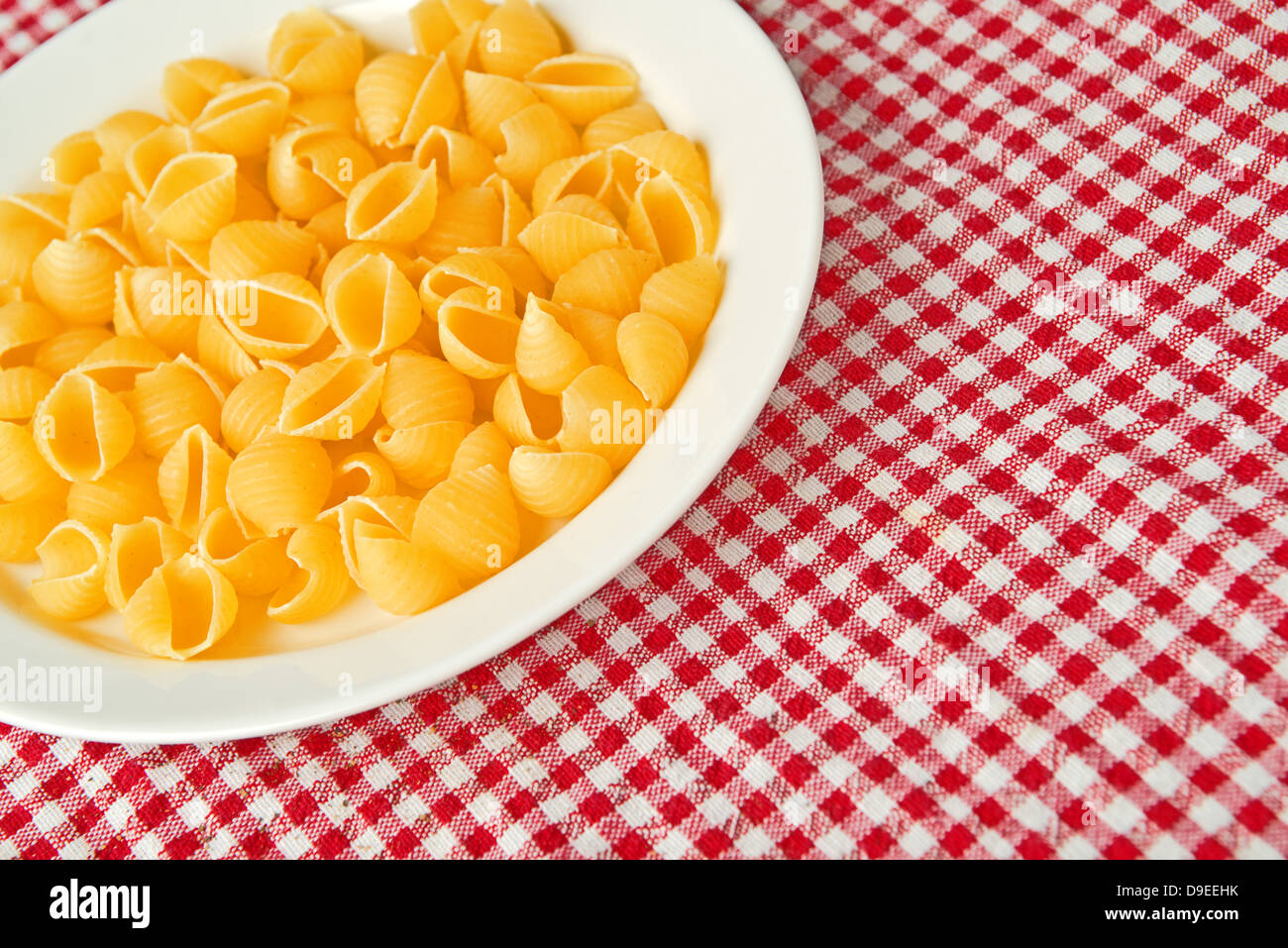 La pasta grezza su piastra bianca sul tavolo da cucina Foto Stock