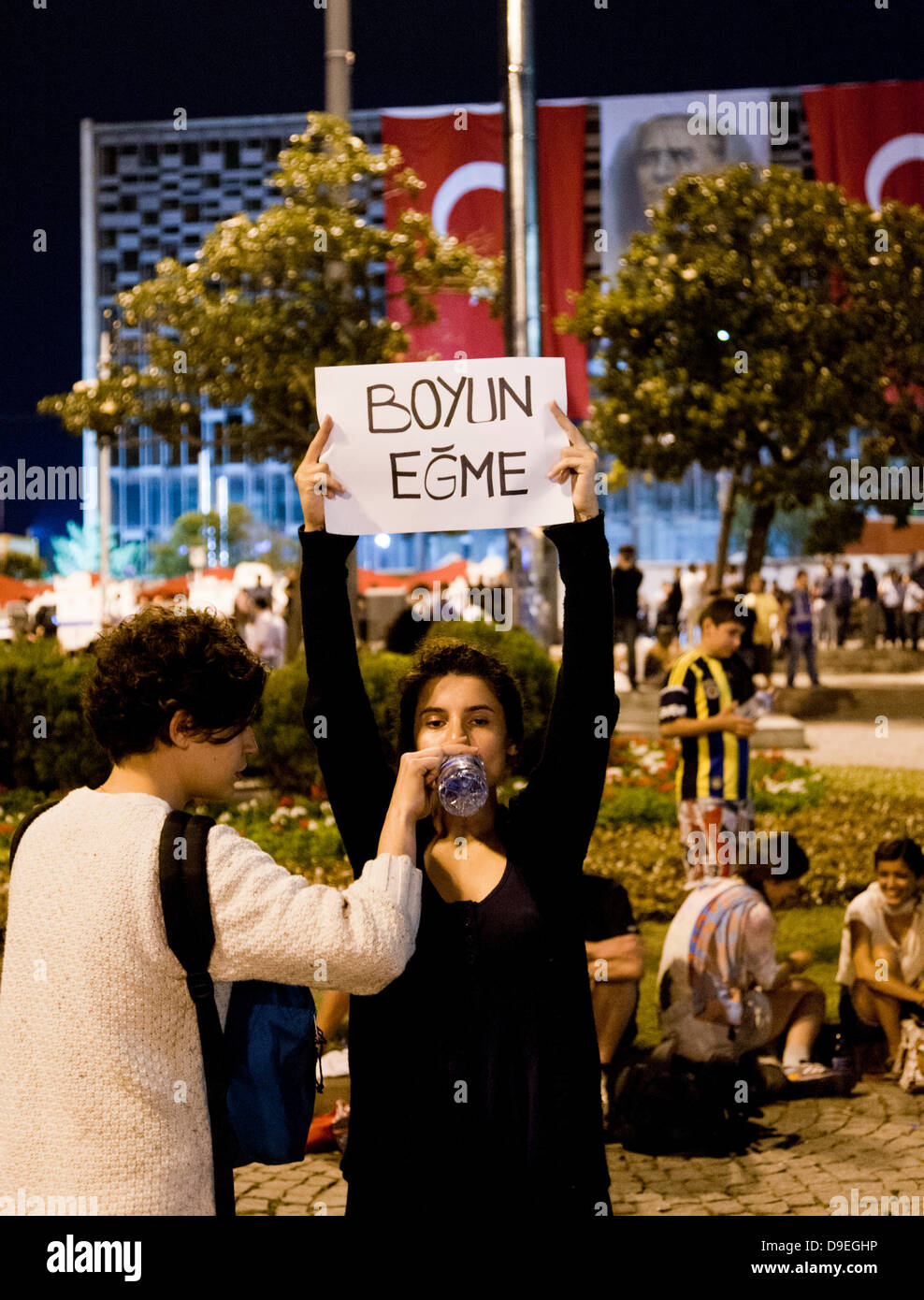 Una donna dimostrando in Piazza Taksim come un segno di protesta contro il governo di Istanbul tenendo un cartello che traduce come resist. Essa è stata data acqua da parte di un collega dimostratore. Credito: David pearson/Alamy Live News Foto Stock
