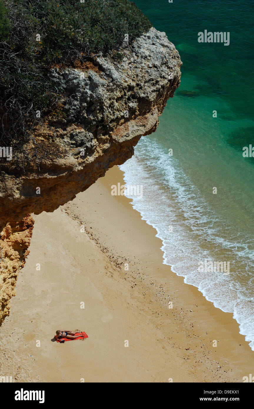 Lonesome adorer solare su una spiaggia Algarve, Portogallo. Foto Stock