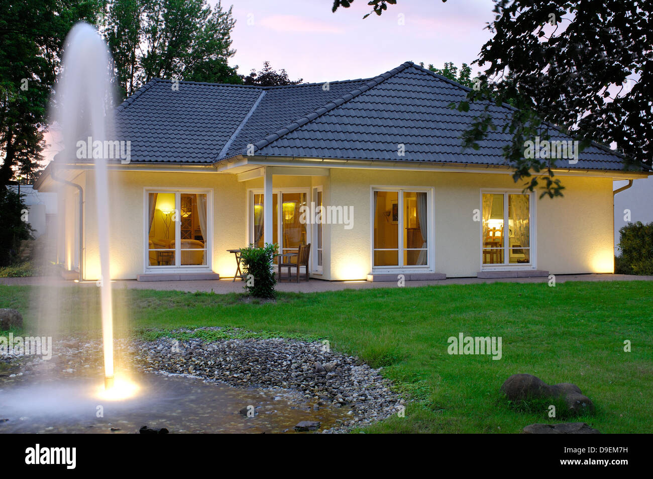 Casa con le luci della sera giardino Foto Stock