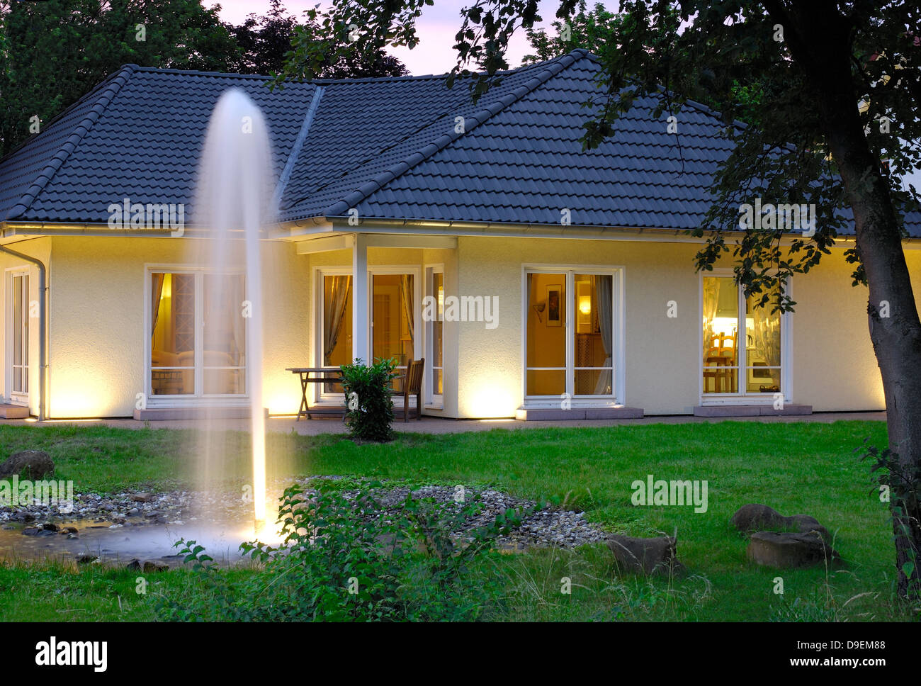 Casa con le luci della sera giardino Foto Stock