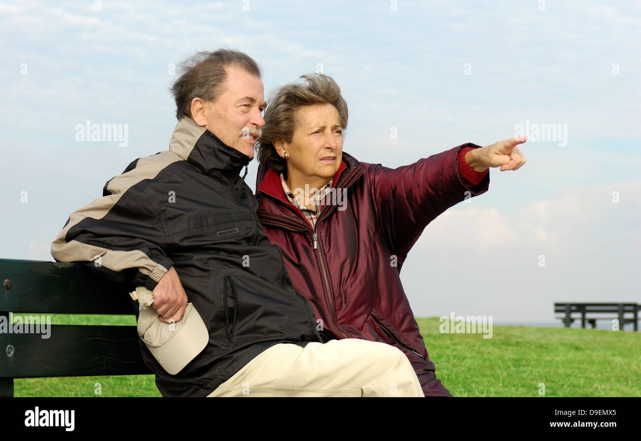 Senior Citizen's coppia siede su un parco-Bench (Modello di rilascio) Foto Stock