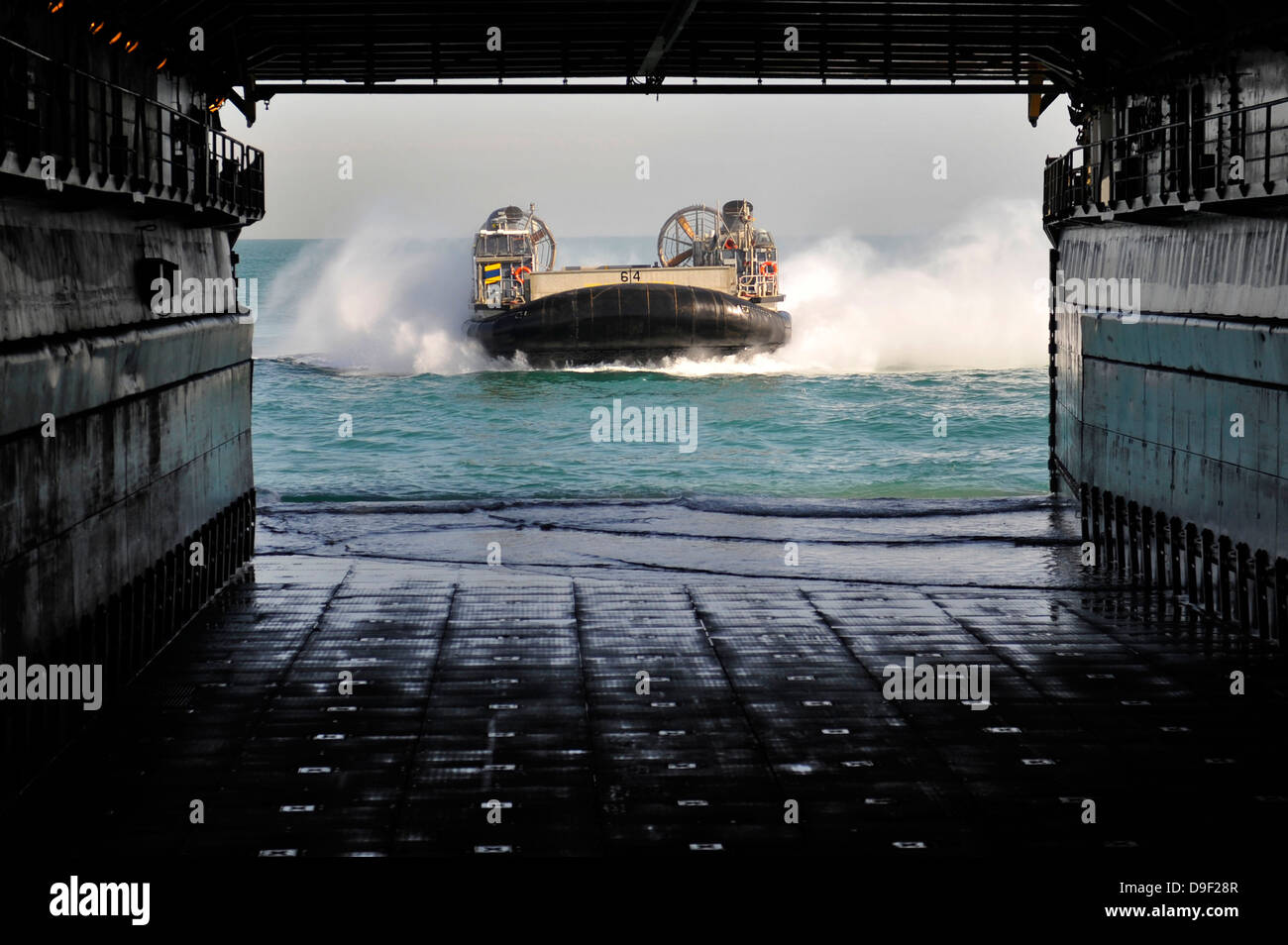 Una Landing Craft Air Cushion si prepara a entrare il bene del ponte della USS Pearl Harbor. Foto Stock