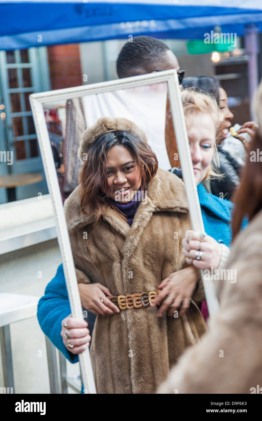 Inghilterra, Londra, Shoreditch, Spitafields Market, Donna acquisto Vintage Pelliccia Foto Stock