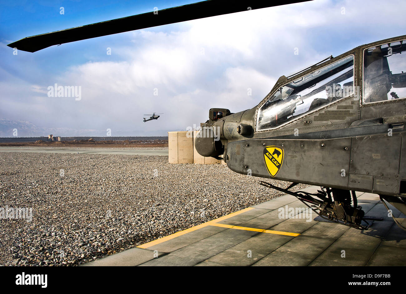 Un AH-64D Apache elicottero proviene in per un atterraggio in una base militare in Afghanistan. Foto Stock