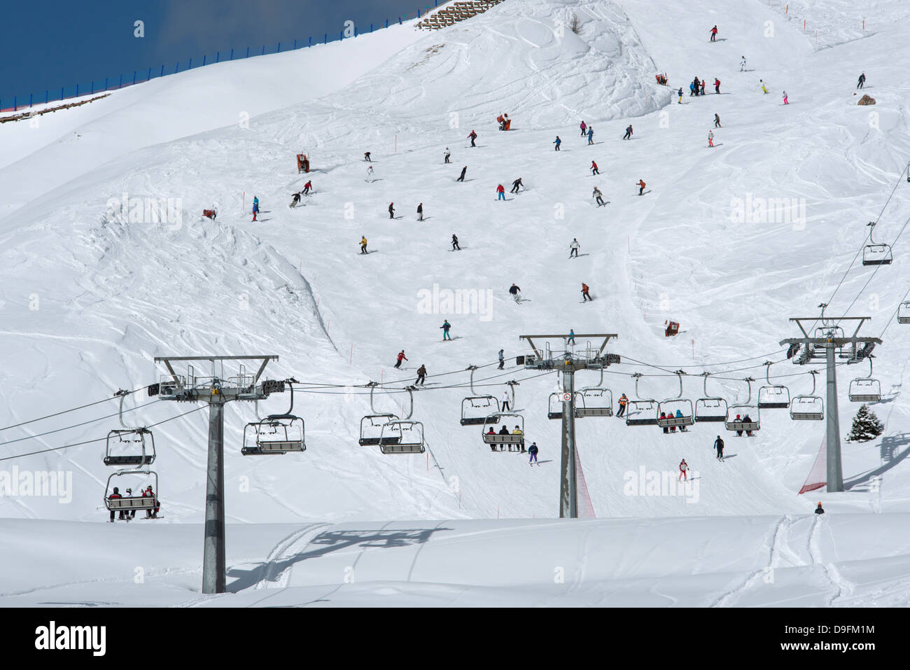 Una seggiovia e sciatori sulle piste al Passo Sella nelle Dolomiti, Alto Adige, Italia Foto Stock