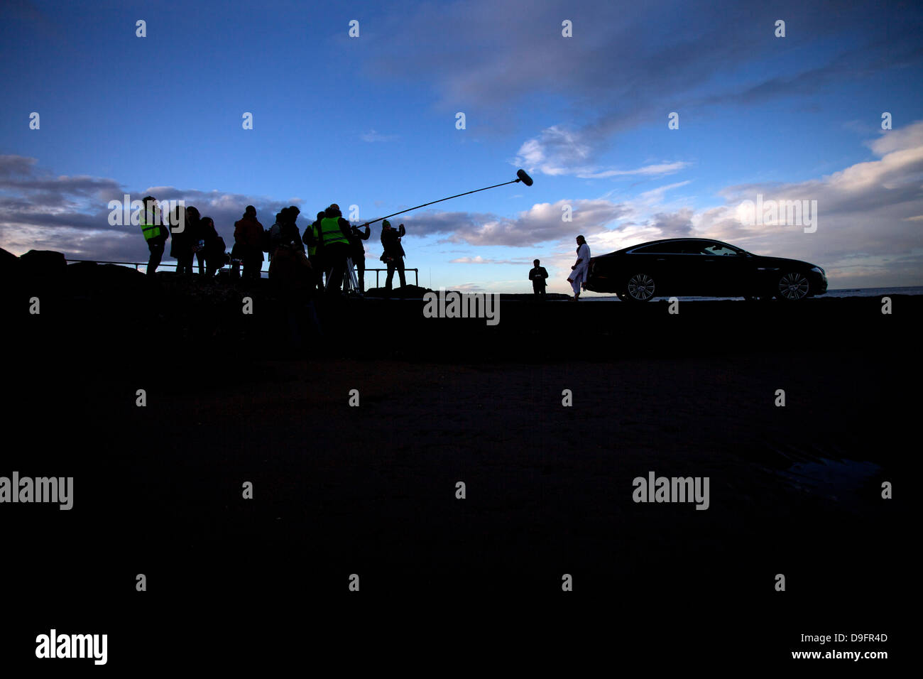 Una troupe cinematografica che gira una scena all'aperto sul posto. Foto Stock