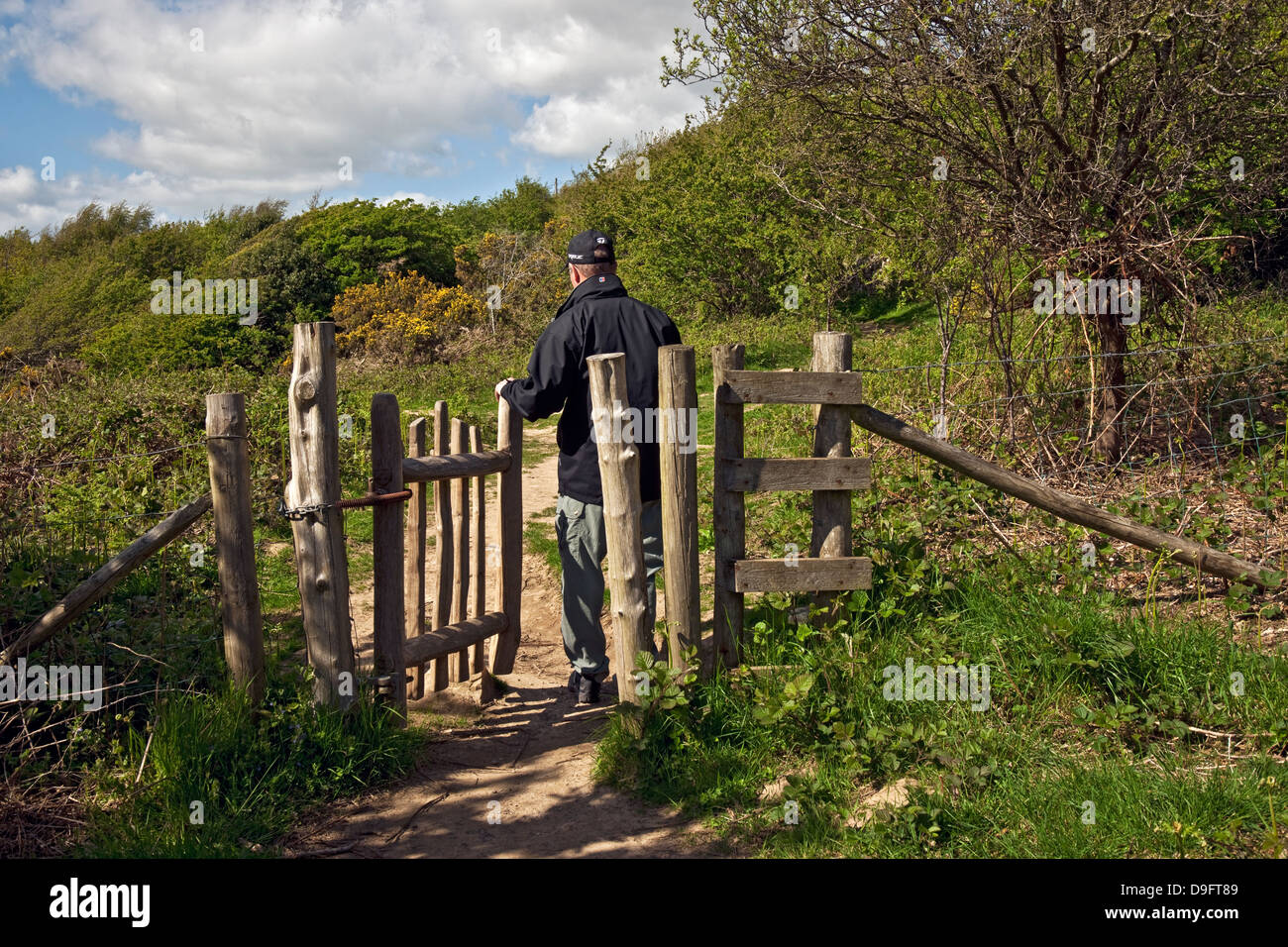 Uomo turista visitatore Walker apertura a piedi attraverso cancello di legno su Footpath Jack Scout Lancashire England UK United Kingdom GB Great La Gran Bretagna Foto Stock