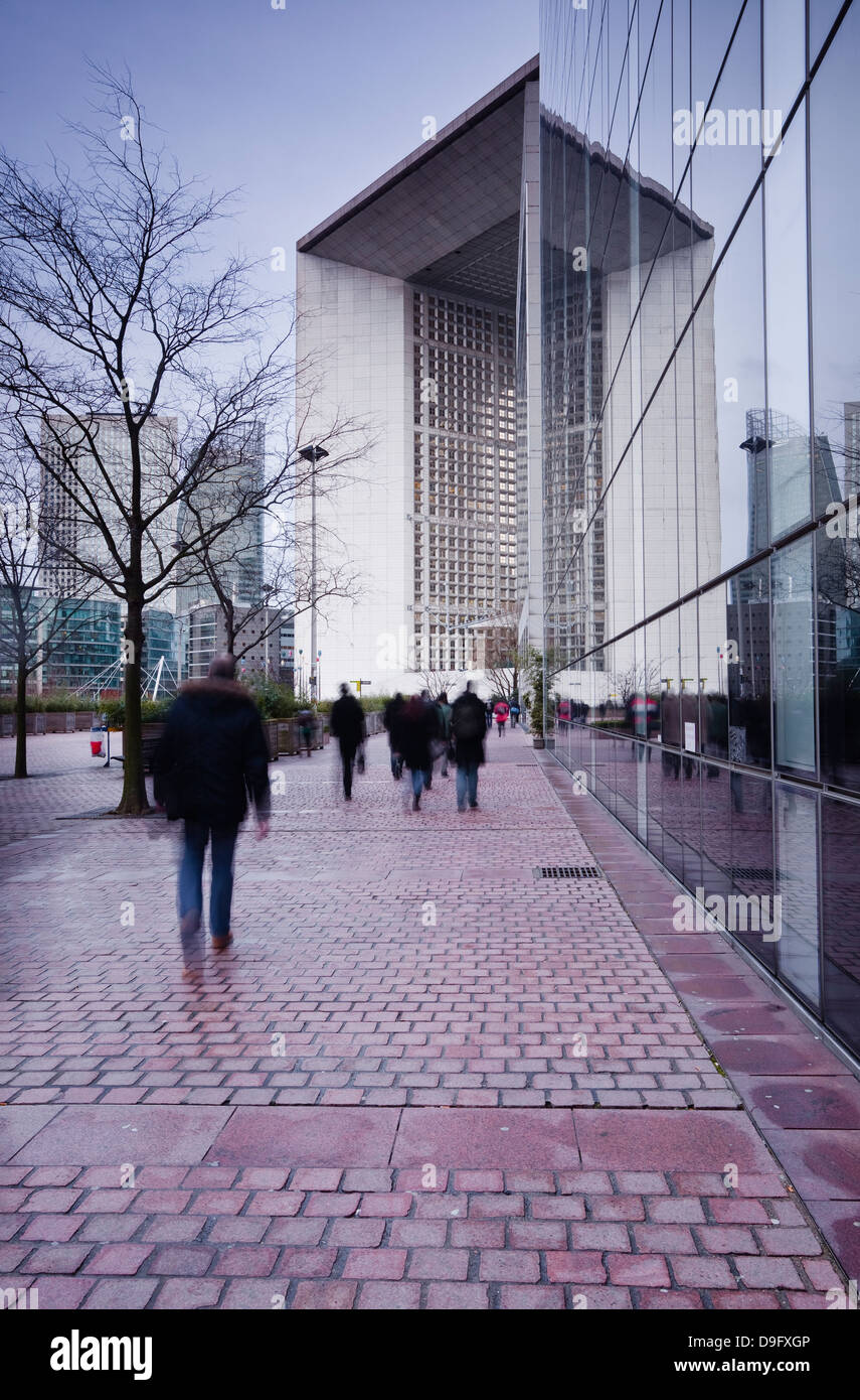 Pendolari lasciando il lavoro in La Defense area con la Grande Arche in background, Parigi, Francia Foto Stock